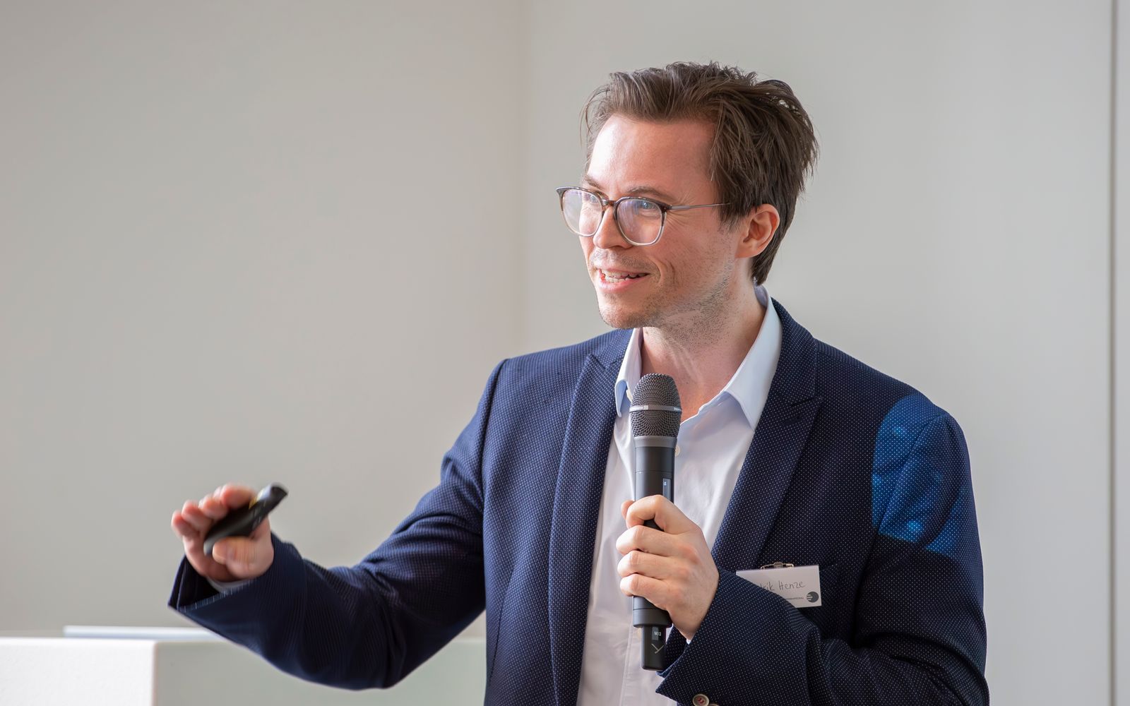 Hendrik Henze mit Mikrofon und Presenter beim TCI-Partnermeeting